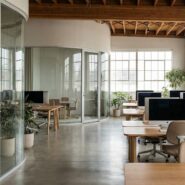 Modern coworking space with empty desks, large screens, and glass interiors