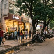 Street view of Indiranagar in Bangalore with cafes, shops, and busy traffic