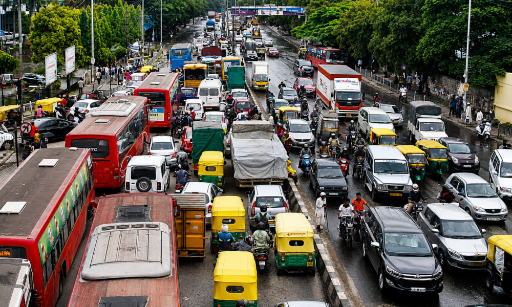 orning traffic at a busy Bangalore junction with cabs, buses, and motorcycles moving through the city.