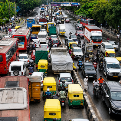 orning traffic at a busy Bangalore junction with cabs, buses, and motorcycles moving through the city.